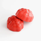 Two vibrant red heirloom tomatoes on white background